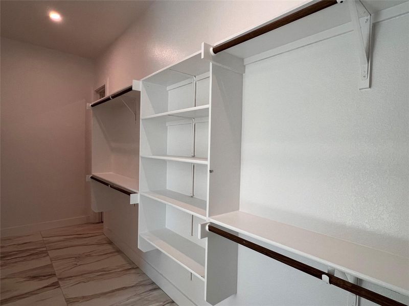 Walk in closet featuring light marble finish floors