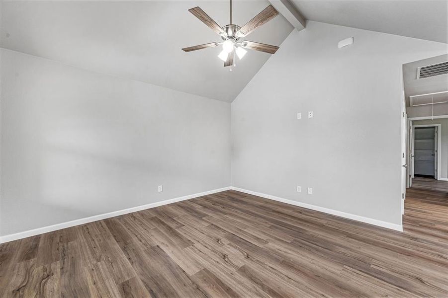 Empty room featuring a ceiling fan, wood finished floors, attic access, and baseboards Empty room featuring a ceiling fan, wood finished floors, attic access, and baseboards