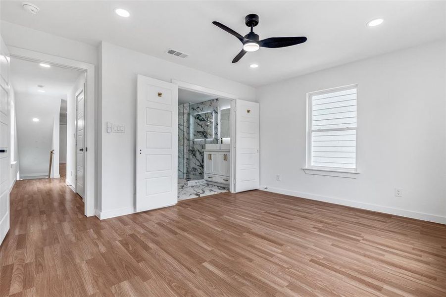 Unfurnished bedroom featuring light wood-style floors, ensuite bathroom, recessed lighting, and a ceiling fan Unfurnished bedroom featuring light wood-style floors, ensuite bathroom, recessed lighting, and a ceiling fan