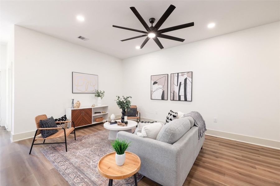 Living room with wood finished floors, recessed lighting, and ceiling fan