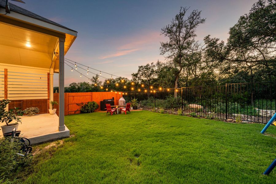 A private, grassy yard invites evening relaxation around a cozy fire pit. A private, grassy yard invites evening relaxation around a cozy fire pit.