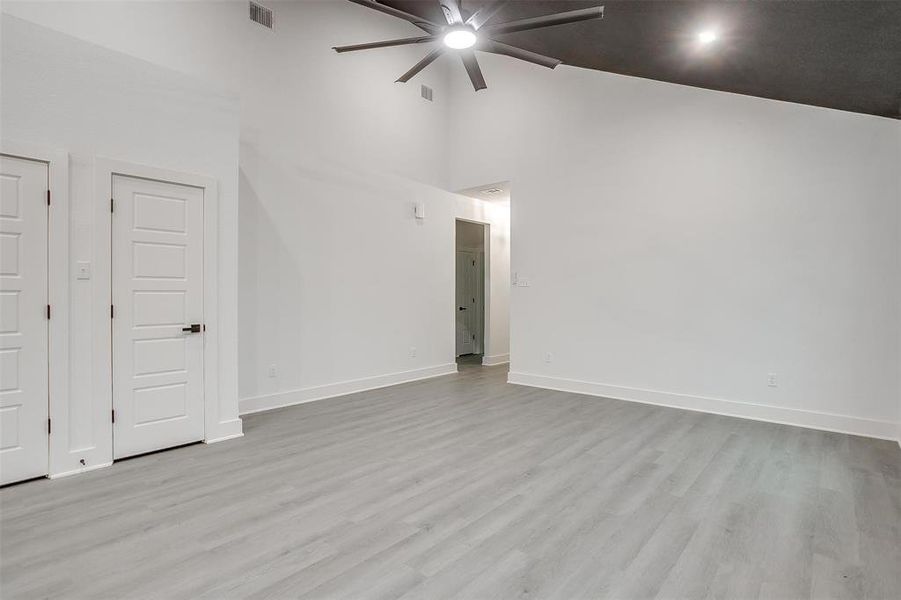 Unfurnished room with a ceiling fan, high vaulted ceiling, and wood finished floors