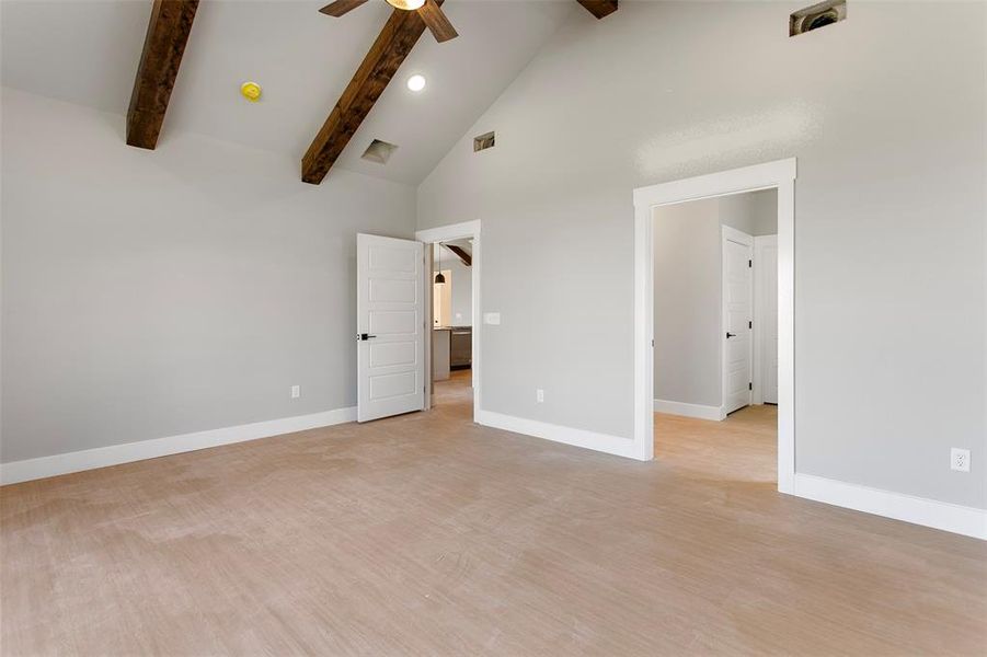 Unfurnished bedroom with ceiling fan, beam ceiling, light wood-type flooring, and high vaulted ceiling