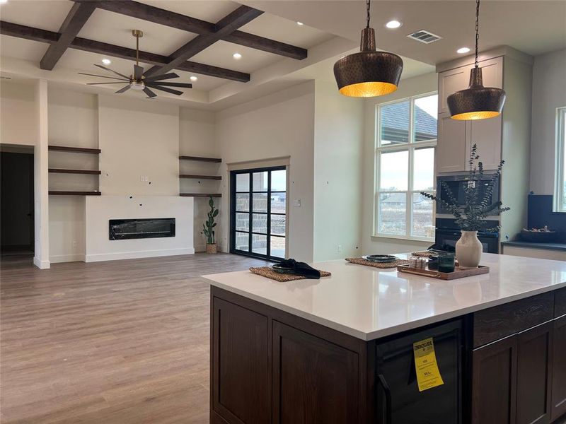 Kitchen with pendant lighting, beverage cooler, a center island, coffered ceiling, and light hardwood / wood-style flooring