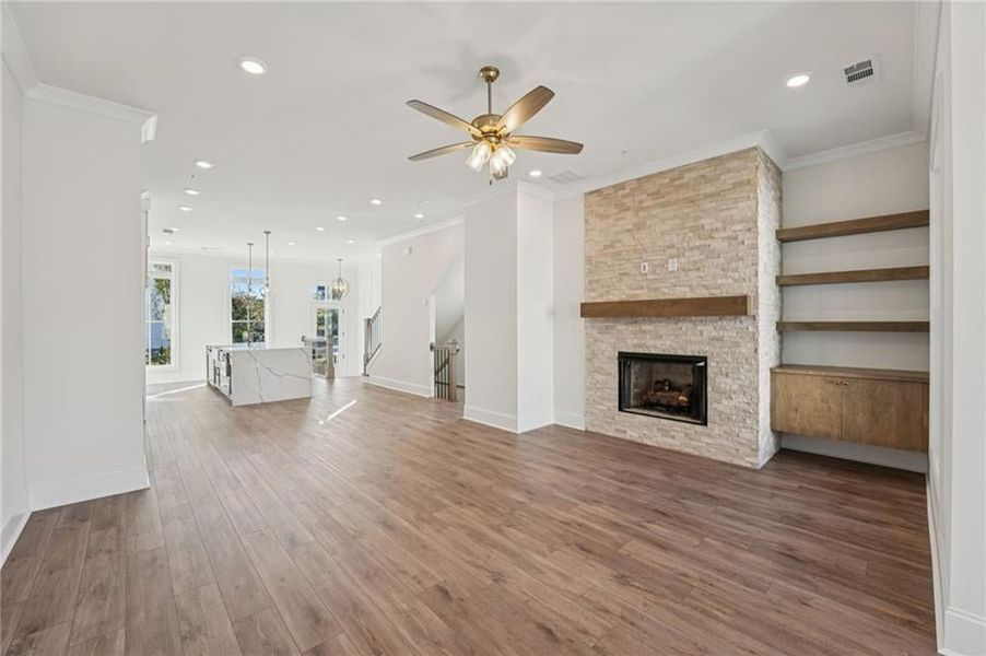 View of living room space from Sunroom space- views right through to the light and bright kitchen and foyer.  Statement light fixtures and pendants in the kitchen help finish out this space. Image is of a previously built Chamberlain plan.