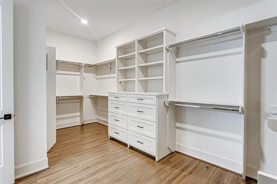 This dream walk-in closet with custom built-ins offers an abundance of space for a large annual wardrobe for TWO!