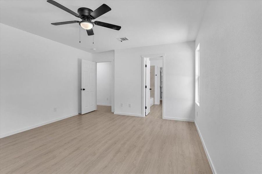 Unfurnished bedroom with ceiling fan and light hardwood / wood-style flooring