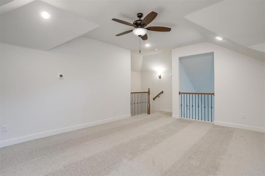 Additional living space featuring lofted ceiling, ceiling fan, and light carpet