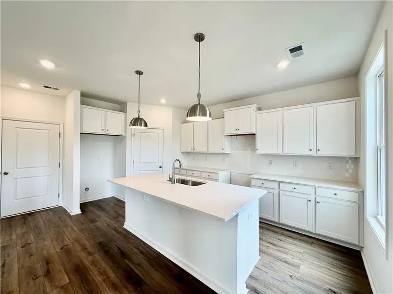 Gleaming stone countertops and a central island an