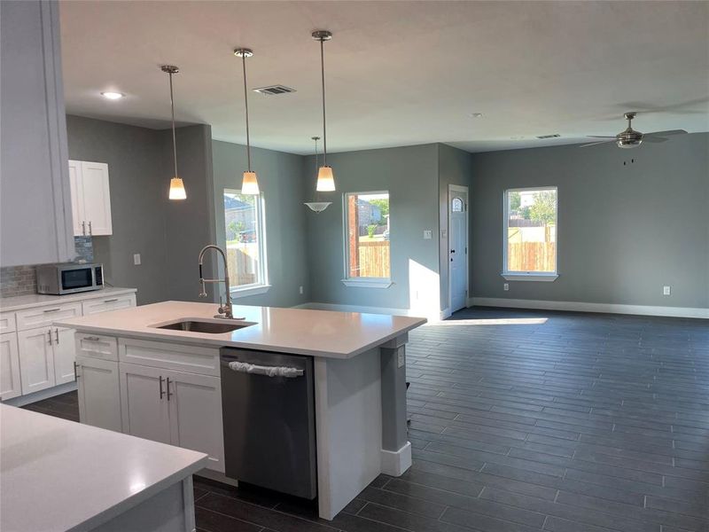 Kitchen with appliances with stainless steel finishes, sink, an island with sink, and white cabinets