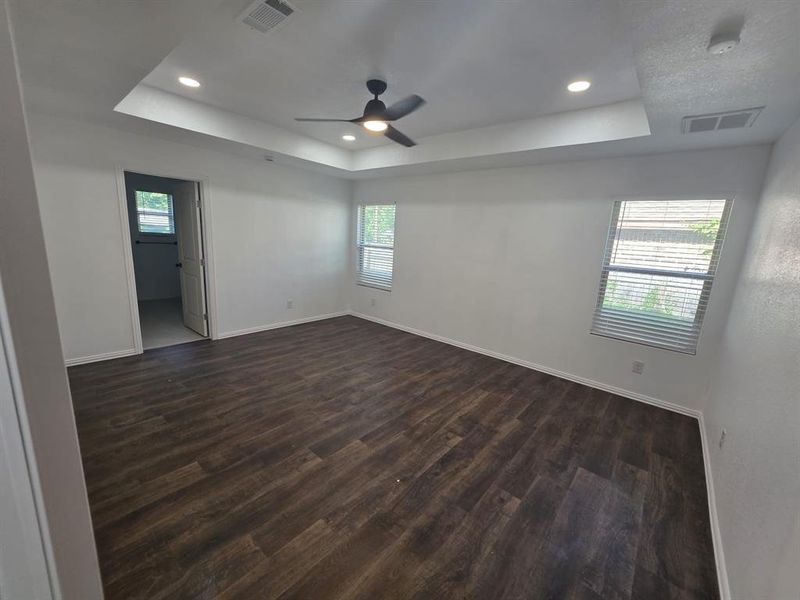 Spare room featuring a raised ceiling, dark wood finished floors, recessed lighting, and ceiling fan Spare room featuring a raised ceiling, dark wood finished floors, recessed lighting, and ceiling fan