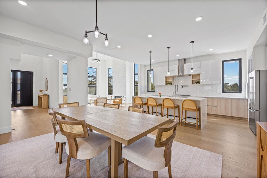 Dining space with light wood-style flooring and suspended lighting
