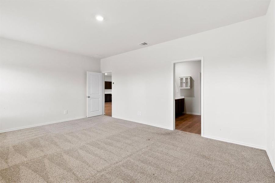 Spacious room featuring neutral carpeting and white wall paint