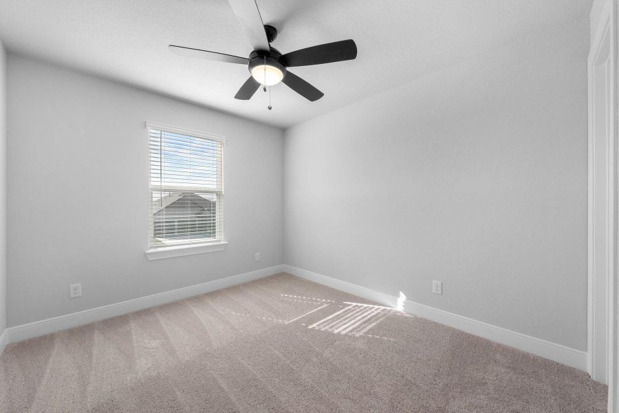 Empty room featuring light carpet and a ceiling fan