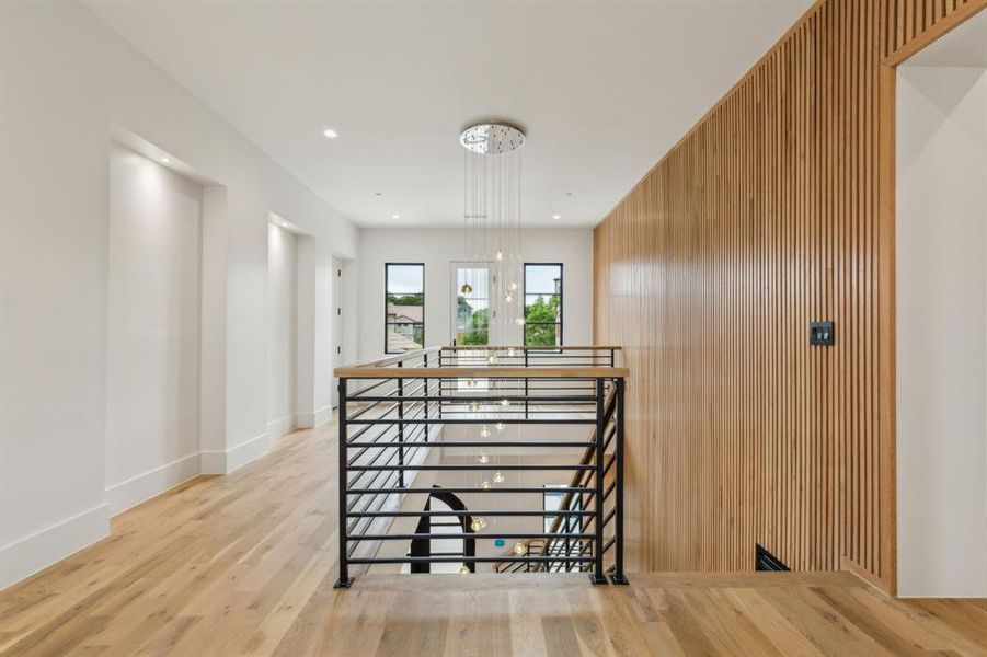 Staircase featuring wood finished floors, wood paneled accents on walls and baseboards Staircase featuring wood finished floors, wood paneled accents on walls and baseboards
