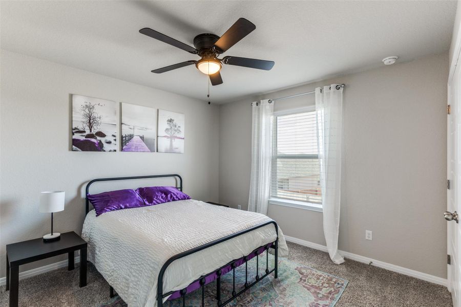 Bedroom with light colored carpet and ceiling fan