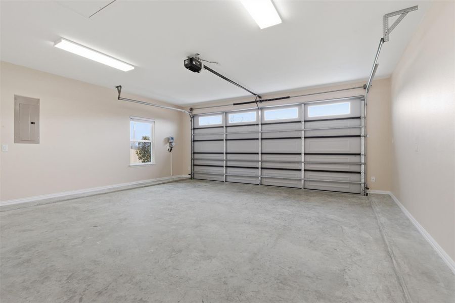 Garage with electric panel and a garage door opener
