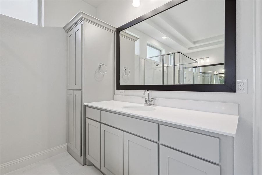 Bathroom featuring tile patterned floors, walk in shower, and vanity