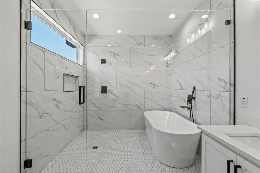 Bathroom featuring plus walk in shower, vanity, and tile patterned flooring