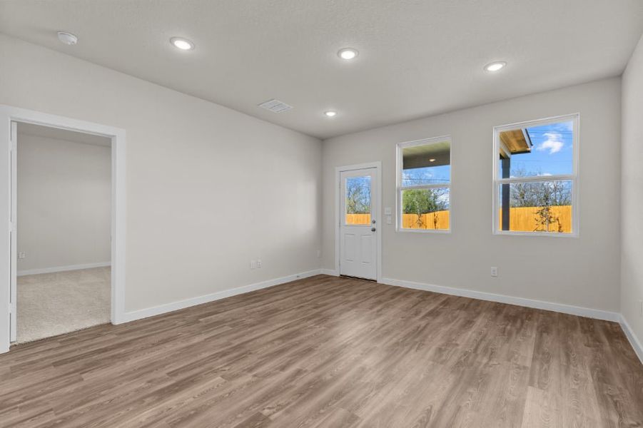 A room with a wood floor and a wood floor with a door and a window with a tree. A room with a wood floor and a wood floor with a door and a window with a tree.