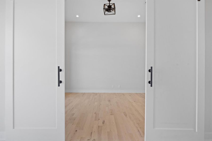 Hall with recessed lighting, baseboards, and wood finished floors leading to an oversized office