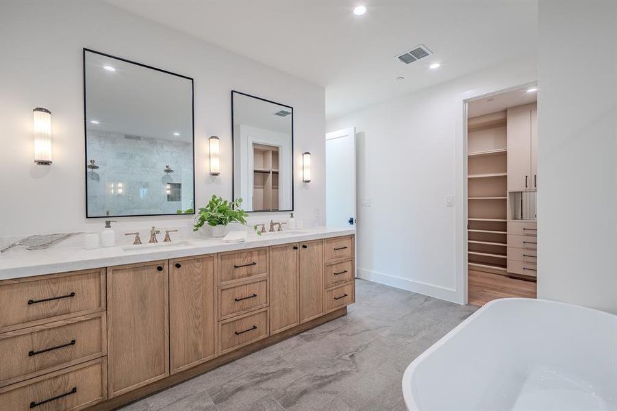 Bathroom featuring double vanity, a tile shower, a freestanding bath, a walk in closet, and recessed lighting Bathroom featuring double vanity, a tile shower, a freestanding bath, a walk in closet, and recessed lighting