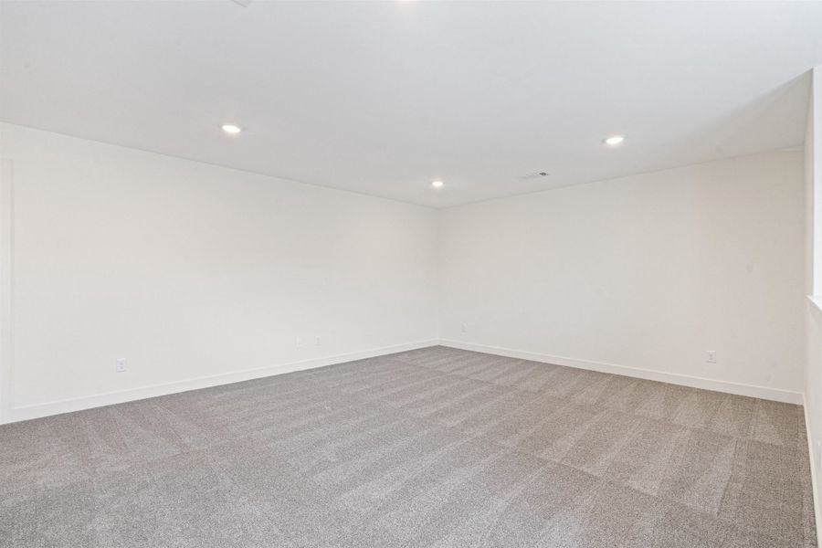 Carpeted spare room featuring recessed lighting and baseboards
