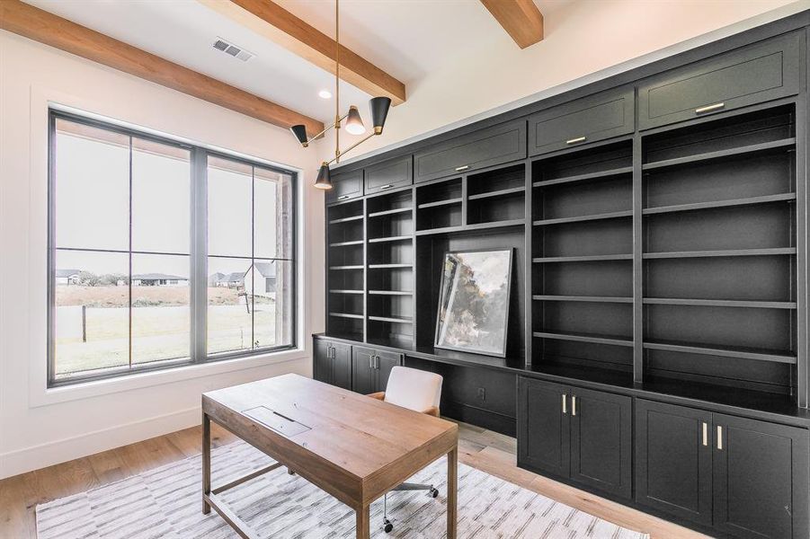 Office space featuring light wood finished floors, beam ceiling, built-in custom cabinetry and recessed lighting.