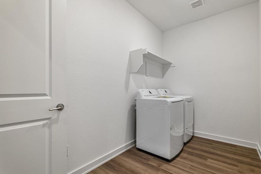 Laundry area featuring independent washer and dryer and dark hardwood / wood-style flooring Laundry area featuring independent washer and dryer and dark hardwood / wood-style flooring
