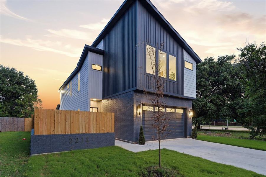 Modern architectural design featuring vertical siding accents and a contrasting brick facade Modern architectural design featuring vertical siding accents and a contrasting brick facade