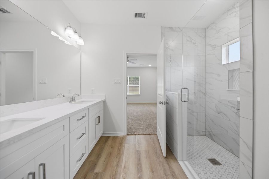 Look at this beautiful ensuite bathroom with double sinks and large tiled shower.