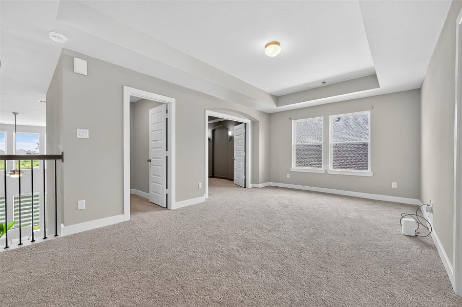 Located just outside the upstairs bedroom, this common area offers flexibility for a media room, lounge, or game space. Tray ceilings and recessed lighting add a touch of elegance to this bright and open retreat.