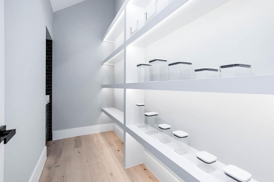 Walk-in pantry featuring LED shelf lighting that highlights organized storage and easy access to all your essentials.