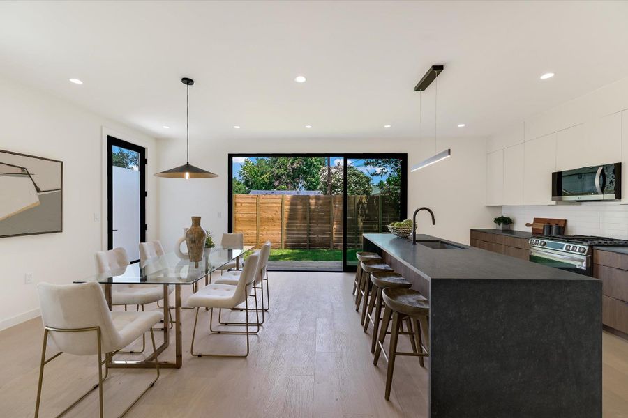 Dining room with light wood-type flooring and recessed lighting