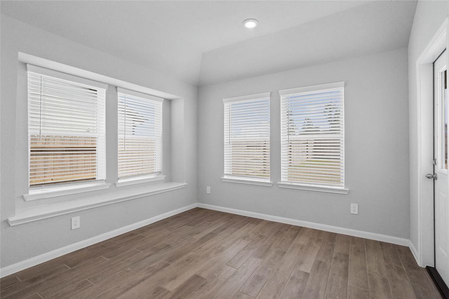 Enjoy meals in this sun-drenched space, featuring durable tile flooring, large windows (fitted with blinds), window seat for added seating, and recessed lighting. An access door to the back covered patio is conveniently located for ease of indoor to outdoor living.