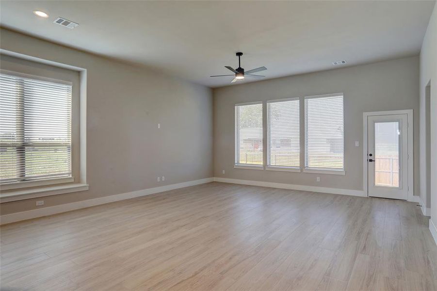 Unfurnished living room featuring light wood-style flooring and ceiling fan Unfurnished living room featuring light wood-style flooring and ceiling fan