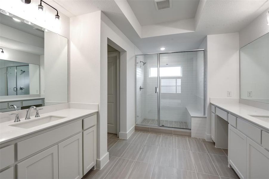 Bathroom featuring vanity, a shower with door, and tile patterned flooring