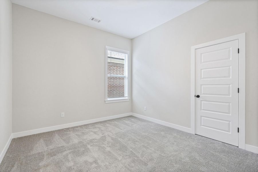 Neutral-toned room featuring a single window with blinds and light gray carpeting Neutral-toned room featuring a single window with blinds and light gray carpeting