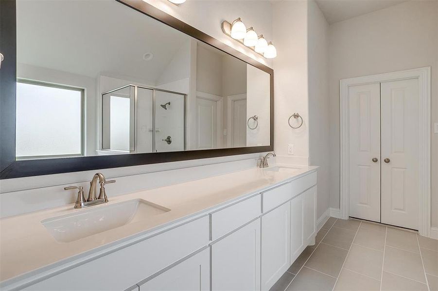 Bathroom featuring tile patterned flooring, vanity, an enclosed shower, and lofted ceiling