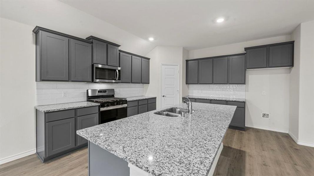 Kitchen featuring a central island, stainless steel sink, and gas range