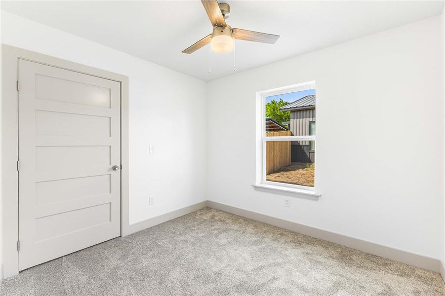Carpeted empty room featuring ceiling fan and baseboards Carpeted empty room featuring ceiling fan and baseboards