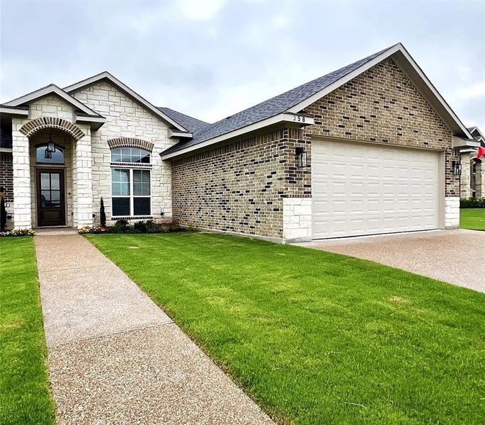 Stone and brick exterior featuring a covered entry with an arched architectural detail Stone and brick exterior featuring a covered entry with an arched architectural detail