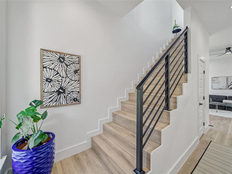 Stairs with hardwood / wood-style floors and ceiling fan