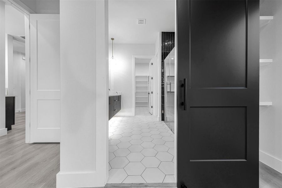 Hallway featuring baseboards and light wood-style flooring. Hallway featuring baseboards and light wood-style flooring.