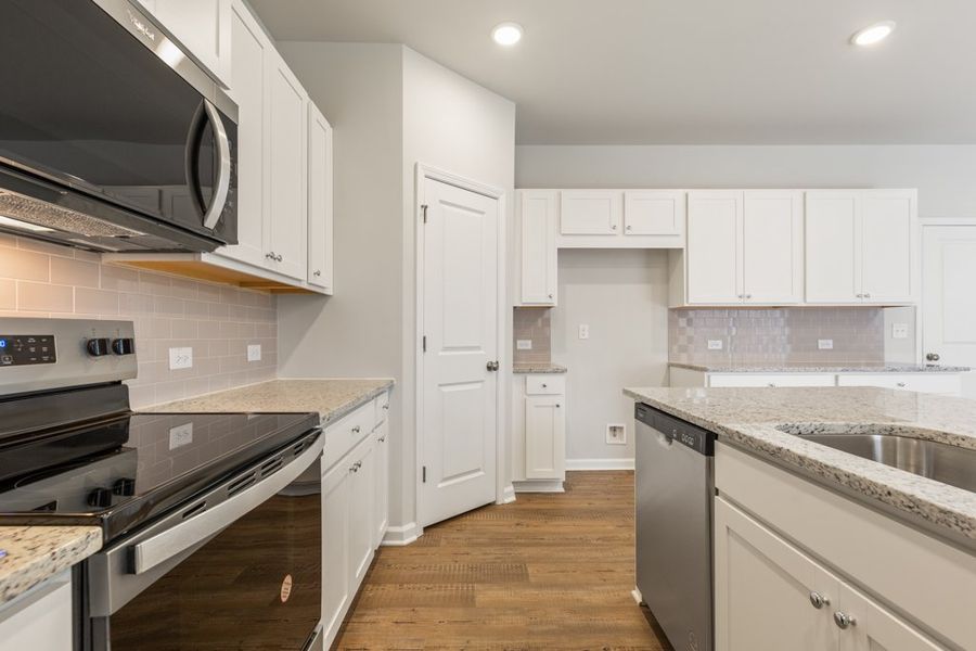 A kitchen with white cabinets.