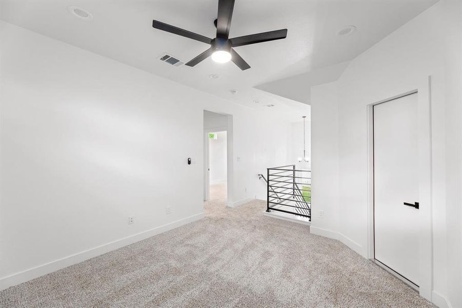 Unfurnished bedroom with visible vents, ceiling fan, baseboards, carpet floors, and multiple windows