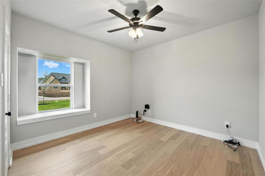 Unfurnished room featuring light wood-style floors and ceiling fan Unfurnished room featuring light wood-style floors and ceiling fan