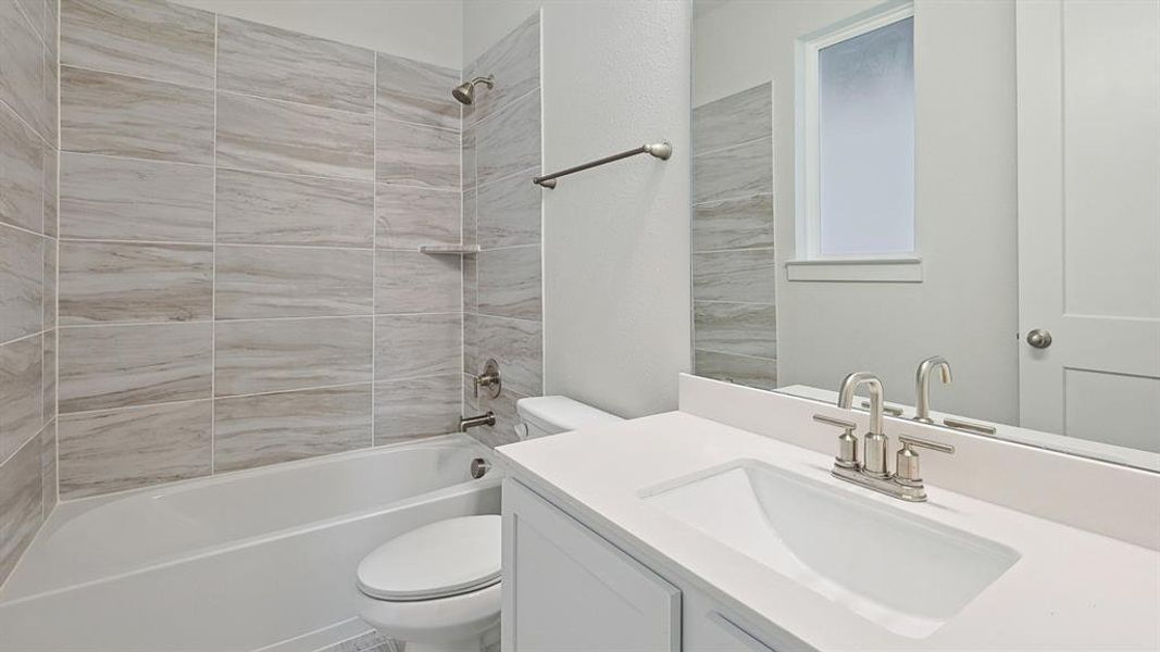 Bathroom featuring a white vanity with an integrated sink, brushed nickel faucet, and a large wall mirror