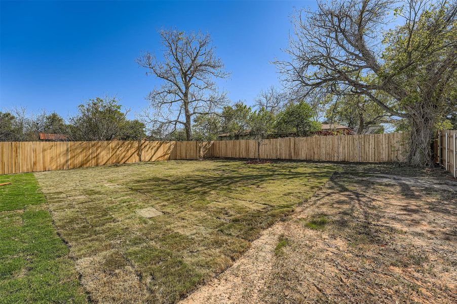 Spacious fenced backyard with plenty of open green space, perfect for outdoor activities and entertaining Spacious fenced backyard with plenty of open green space, perfect for outdoor activities and entertaining