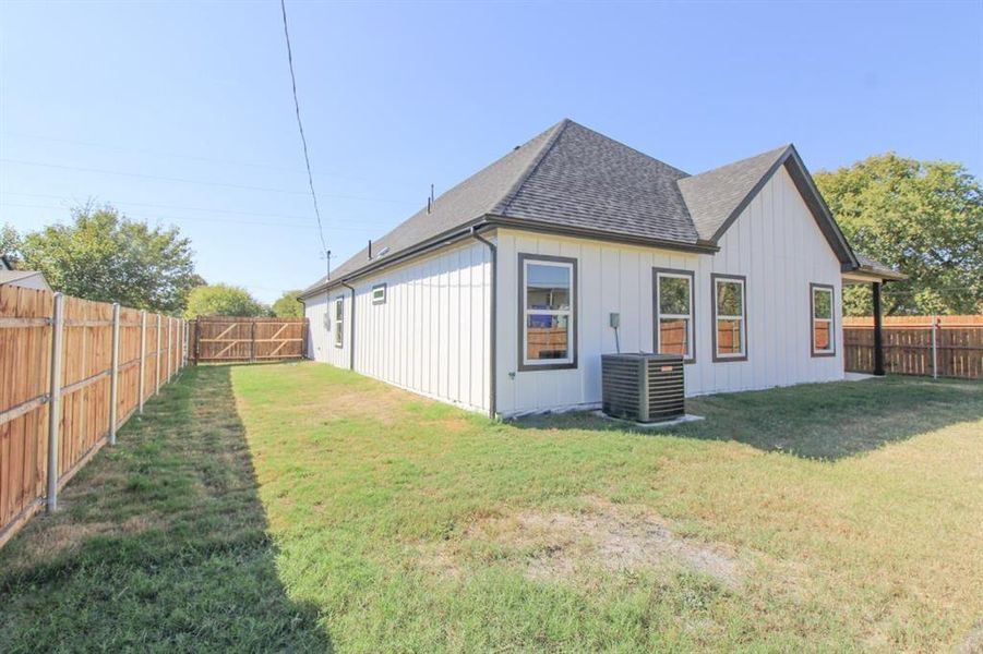 View of property exterior featuring roof with shingles, a fenced backyard, and board and batten siding View of property exterior featuring roof with shingles, a fenced backyard, and board and batten siding